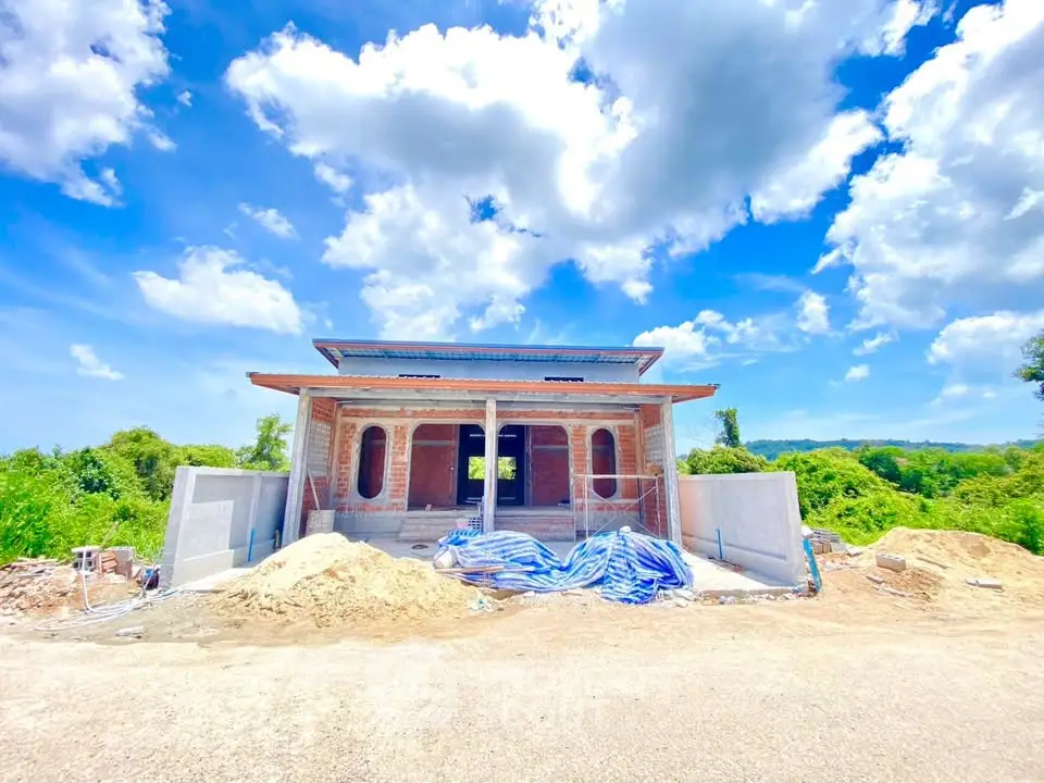 Stunning under-construction house with clear blue sky and lush greenery, showcasing potential for a dream home.