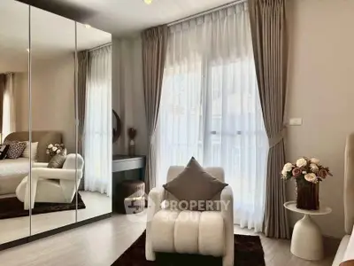 Elegant bedroom with mirrored wardrobe and cozy armchair, perfect for relaxation.