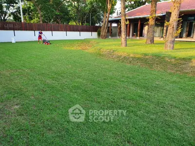 Spacious garden with lush green lawn and modern house in background