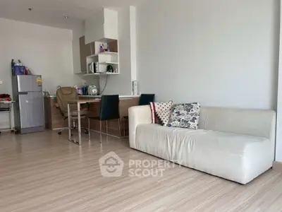 Modern living room with sleek furniture and compact kitchen area, perfect for urban living.