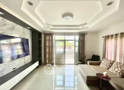 Spacious living room with modern ceiling design and large windows for natural light.