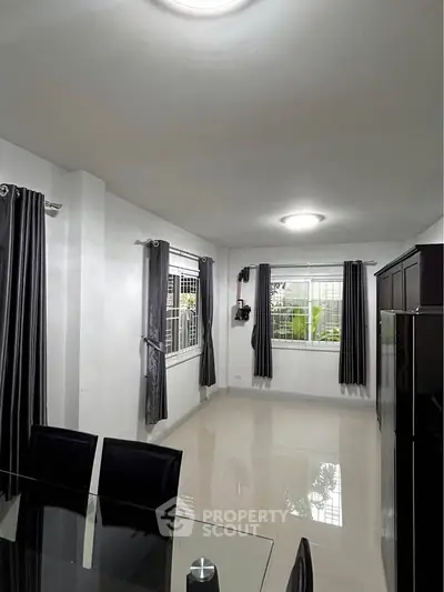 Spacious dining area with modern decor and large windows for natural light.