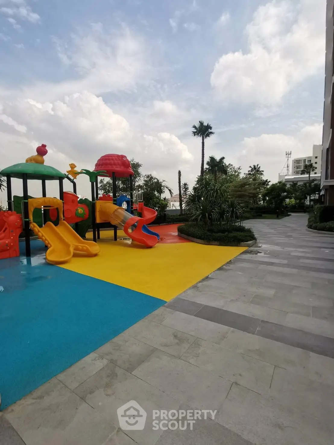 Modern residential playground with colorful slides and lush landscaping, perfect for family-friendly living.