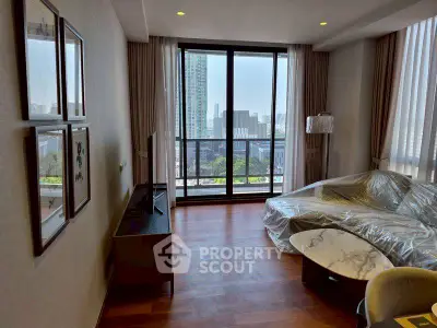Modern living room with city view, large windows, and stylish decor in high-rise apartment.
