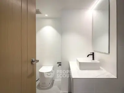 Modern minimalist bathroom with sleek fixtures and neutral tones.