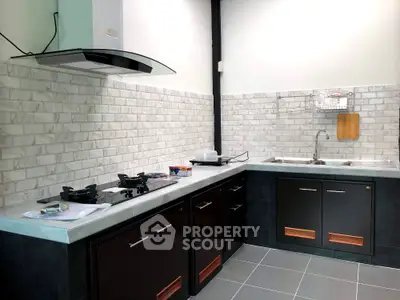 Modern kitchen with sleek black cabinets and gas stove
