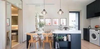 Modern kitchen with open layout and stylish dining area, featuring pendant lights and built-in appliances.
