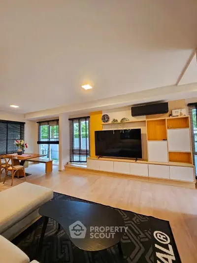 Spacious modern living room with stylish decor and large TV unit, perfect for relaxation and entertainment.