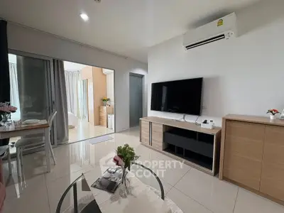 Modern living room with sleek design, featuring a large TV, air conditioning, and elegant furniture.