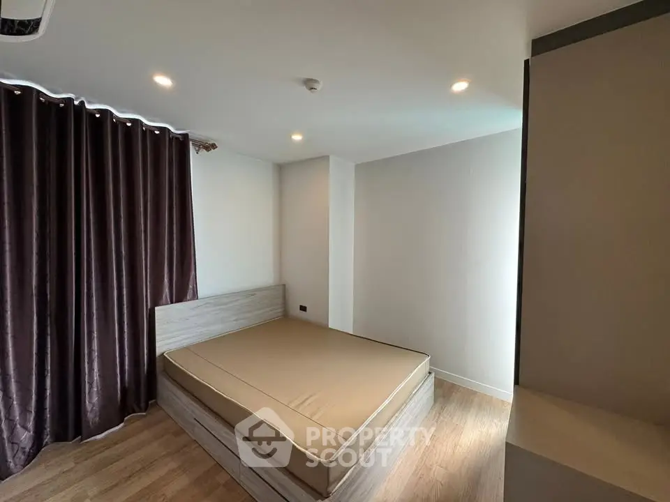 Modern minimalist bedroom with wooden flooring and elegant curtains