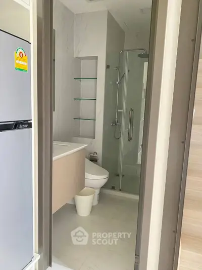 Modern bathroom with glass shower and sleek fixtures in a contemporary apartment.