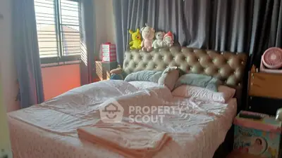 Cozy bedroom with plush headboard and soft lighting, perfect for relaxation.