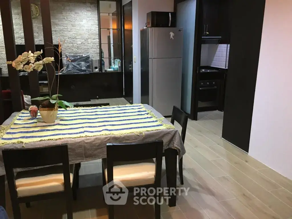 Modern dining area with table, chairs, and kitchen view in stylish apartment.