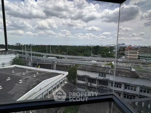 Stunning cityscape view from high-rise building window showcasing urban skyline and lush greenery.