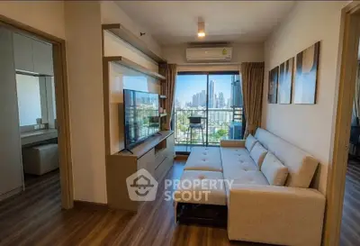 Modern living room with city view, featuring a sleek sofa and entertainment unit, perfect for urban living.