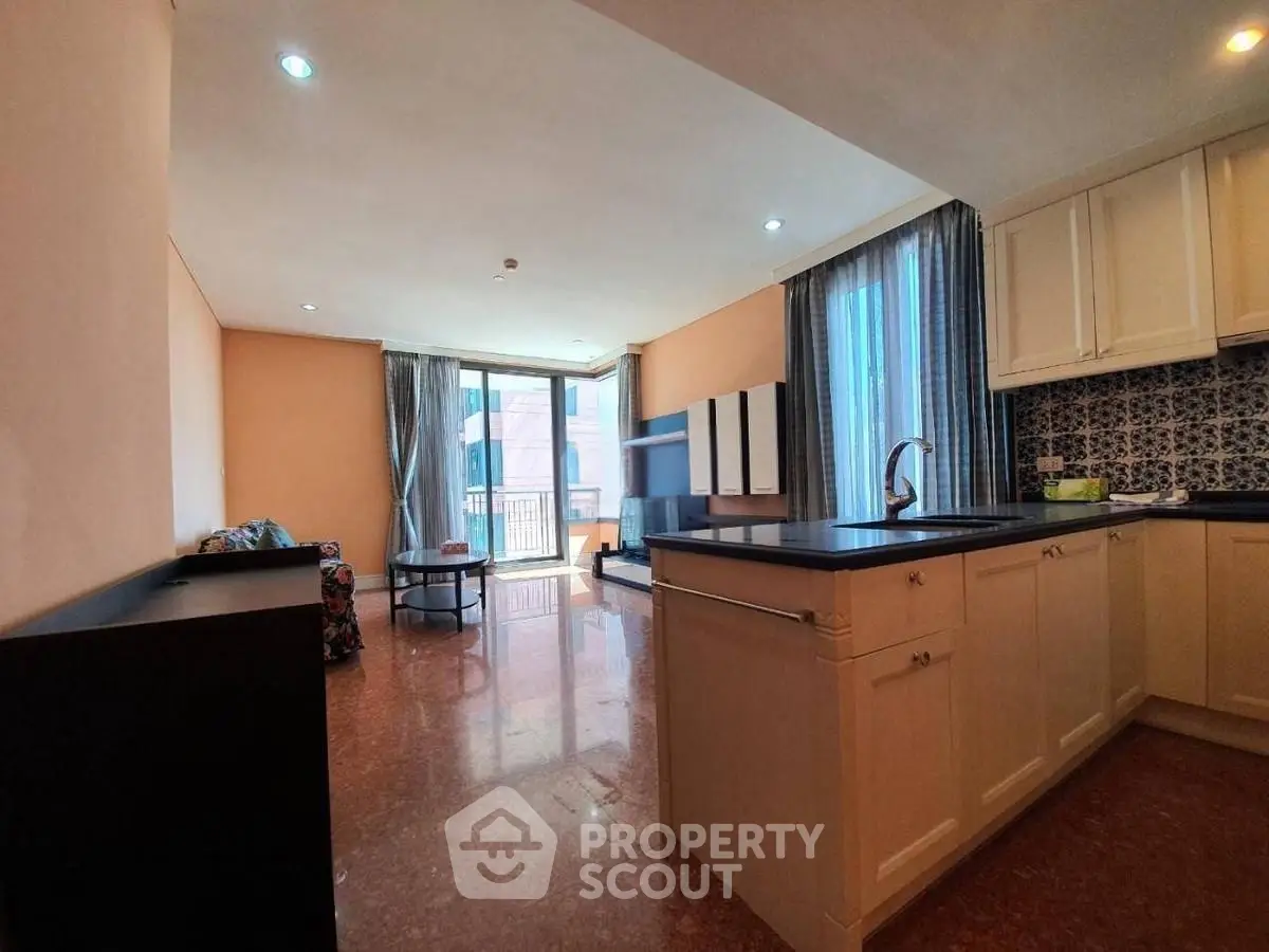 Spacious open-plan living room with modern kitchen and balcony view