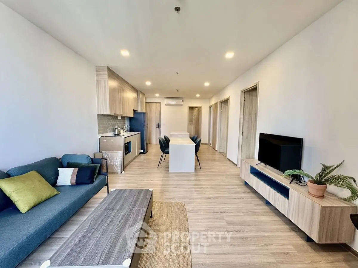 Modern open-plan living room with stylish furniture and kitchen area