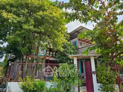 Charming two-story house with lush garden and vibrant exterior in a serene neighborhood.