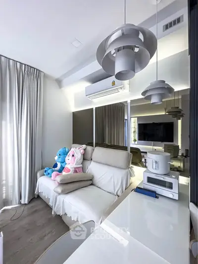 Modern living room with stylish lighting and plush seating, featuring a cozy ambiance and contemporary decor.