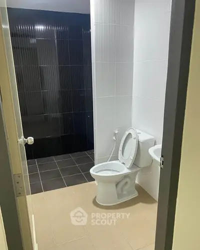 Modern bathroom with sleek black and white tiles and contemporary fixtures.