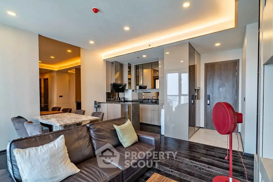 Luxurious modern living room with open kitchen and elegant dining area in high-rise apartment.