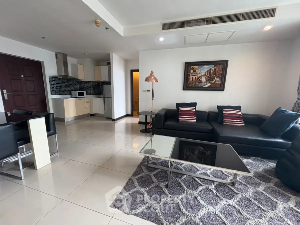 Modern open-layout living room with sleek kitchen and stylish decor.