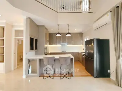 Modern kitchen with open layout, sleek cabinetry, and stylish lighting in a spacious home interior.