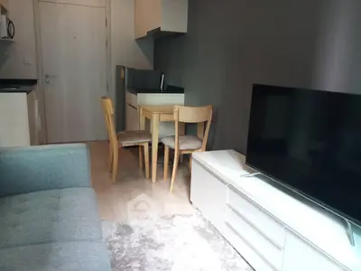 Modern living room with compact kitchen and cozy dining area in stylish apartment.