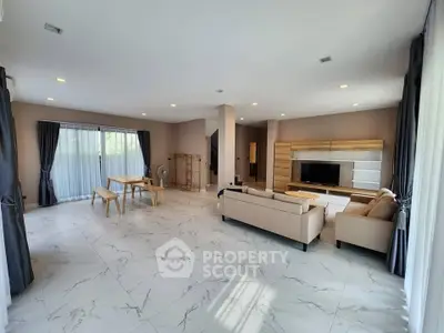 Spacious modern living room with elegant marble flooring and stylish furniture, perfect for family gatherings.
