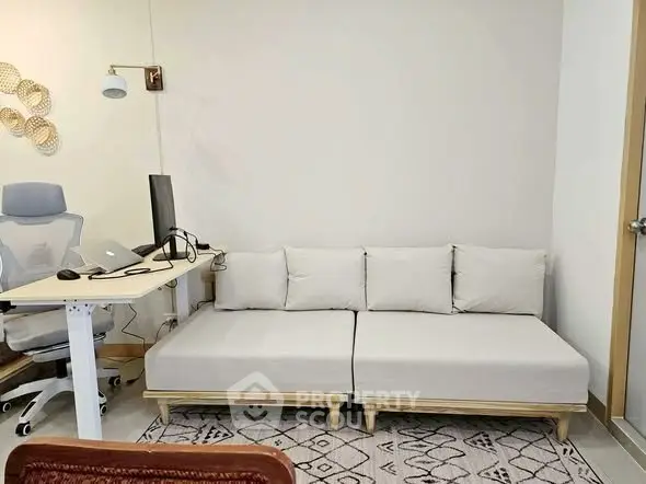 Modern study room with ergonomic chair, desk, and cozy sofa for productivity and relaxation.