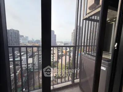High-rise balcony with cityscape view and modern appliances.