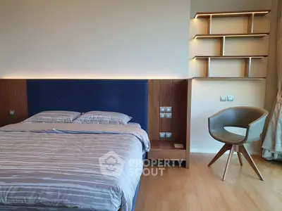 Modern bedroom with stylish shelving and elegant chair, featuring a cozy bed and ambient lighting.
