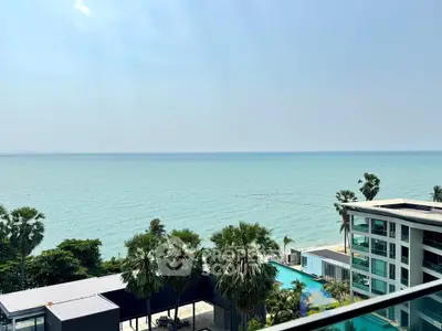 Stunning ocean view from a modern beachfront property with palm trees and pool.