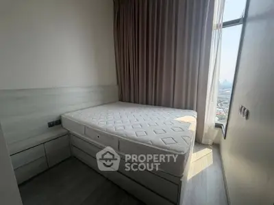 Cozy bedroom with large window offering stunning city views, featuring a comfortable bed and elegant curtains.