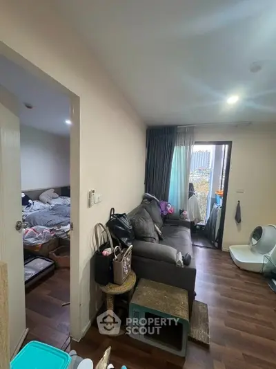 Cozy living room with wooden flooring and balcony access in modern apartment