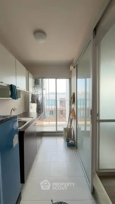 Modern kitchen with sleek cabinets and ocean view from large window.