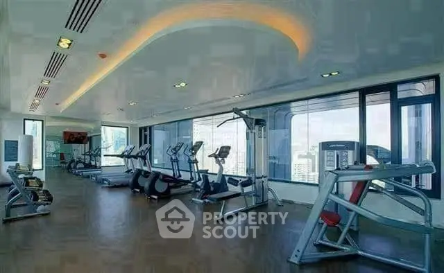 Luxurious high-rise gym with panoramic city views and modern fitness equipment.