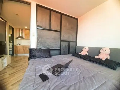 Cozy bedroom with modern decor and view into stylish kitchen