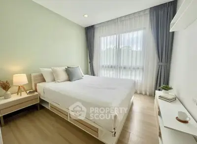 Bright and airy bedroom with modern decor and large window view.