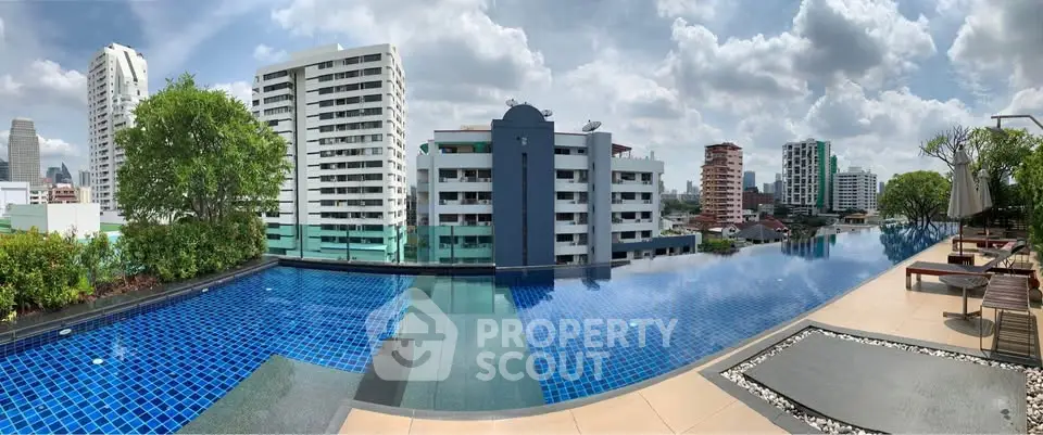 Stunning rooftop pool with city skyline views and modern lounging area.