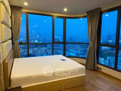 Luxurious corner bedroom with panoramic city view and floor-to-ceiling windows.