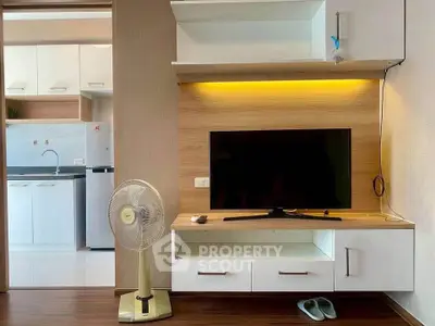 Modern living room with sleek TV unit and view into stylish kitchen