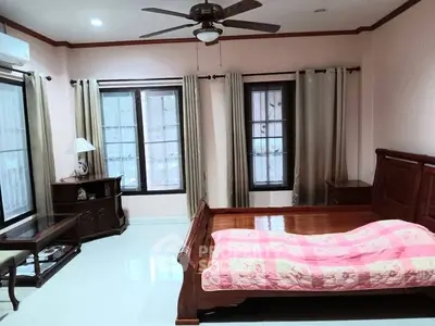Spacious bedroom with wooden furniture and large windows