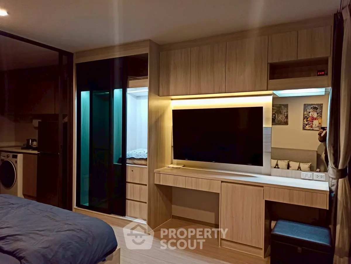 Modern bedroom with built-in wardrobe and entertainment unit, featuring sleek design and cozy ambiance.