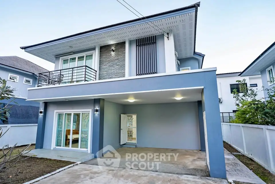Modern two-story blue house with balcony and spacious driveway