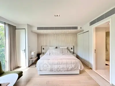 Luxurious bedroom with modern decor and large windows offering natural light.