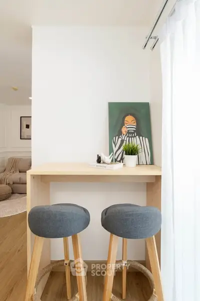 Modern minimalist interior with stylish bar stools and art decor, perfect for cozy living spaces.