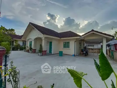 Charming single-story house with spacious driveway and lush greenery, perfect for serene living.