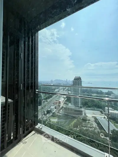 Stunning high-rise balcony view overlooking cityscape and ocean horizon.