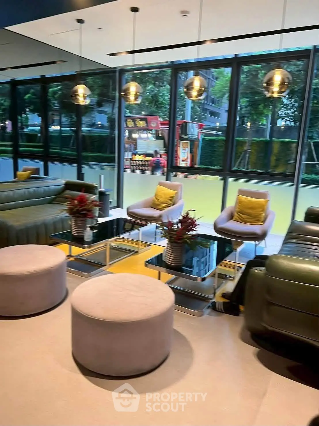 Luxurious modern living room with stylish furniture and large windows offering a vibrant city view.